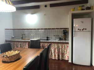 uma cozinha com uma mesa e um frigorífico branco em CASA RURAL BUENAVISTA em Guarazoca