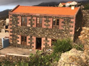 an old stone house with an orange roof at CASA RURAL BUENAVISTA in Guarazoca