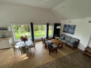 a living room with a table and a couch at Leśny domek in Chmielno