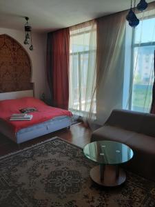 a bedroom with a bed and a couch and a table at Гостевой дом in Chornomorsk