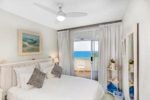 a bedroom with a white bed with a view of the ocean at 43 Sea Lodge - by Stay in Umhlanga in Durban