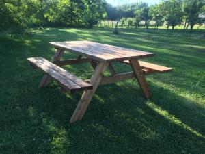 una mesa de picnic de madera en el césped en Chambres d'hote le Prelude en Saint-Martin-des-Noyers
