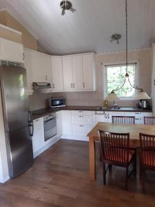 韋斯特羅斯的住宿－The Cottage Badelunda，厨房配有桌子和不锈钢冰箱。
