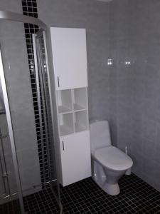 La salle de bains est pourvue de toilettes et d'une armoire blanche. dans l'établissement The Cottage Badelunda, à Västerås