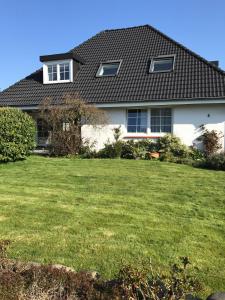 una casa con un césped verde delante de ella en Haus-Norderpiep, en Büsum