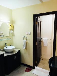 Urban Rose Hotel & Apartments في دار السلام: حمام مع حوض ومرآة