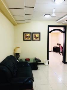- un salon avec un canapé noir et une table dans l'établissement Urban Rose Hotel & Apartments, à Dar es Salaam