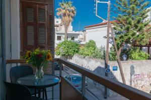 een balkon met een tafel en een vaas met bloemen bij Elena’s Sweet Home in Downtown Chania in Chania