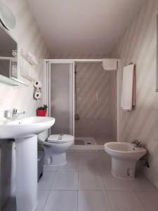 Un baño con ducha, lavabo e inodoro. en Hostal Senero, en Mérida
