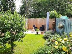 a garden with two chairs and a fence at Highland Home From Home in Inverness