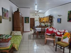 eine Küche und ein Wohnzimmer mit einem Tisch und Stühlen in der Unterkunft Private Room in our Home Stay by Kohutahia Lodge, 7 min by car to airport and town in Faaa