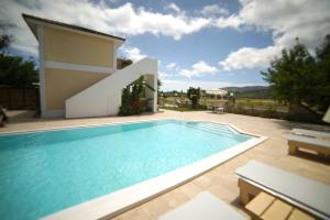 a swimming pool in front of a house at Mirsini Studios & Apartments in Laganas