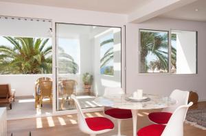 a dining room with a table and chairs and palm trees at Casa Damienne in Porto Cristo