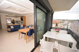 a room with a balcony with a table and chairs at Saatli Suites in Çeşme