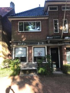 ein Haus mit einer Bank davor in der Unterkunft B&B de Dorpsdokter in Udenhout