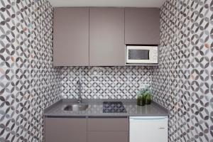 a kitchen with a sink and a microwave at Apartamentos Ribera in Benidorm