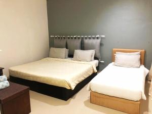 Habitación con 2 camas y mesa. en HOTEL SHAFURA 2 en Cukai