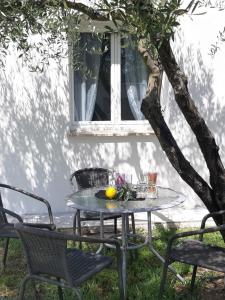una mesa y sillas bajo un árbol con una naranja. en Le coin des Oliviers en Puget-sur Argens