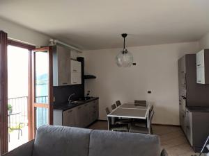 een woonkamer met een bank en een keuken met een tafel bij SWEET VIEW in Varenna