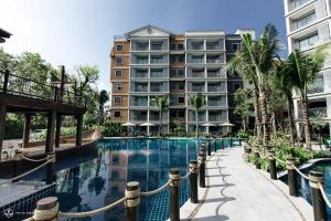 a swimming pool in front of a large building at Title Residence Naiyang Beach Phuket in Nai Yang Beach