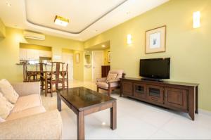 a living room with a couch and a tv at VIP Suite Seaview Batu Ferringhi 1003-2 Bedroom in Batu Ferringhi