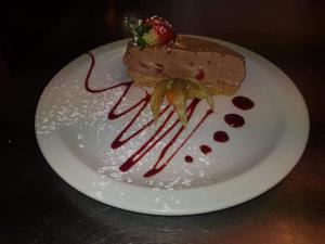 a white plate with a dessert with a strawberry on it at Usk And Railway Inn in Sennybridge
