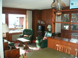 een woonkamer met groene stoelen en een tafel bij Belcombes in Verbier
