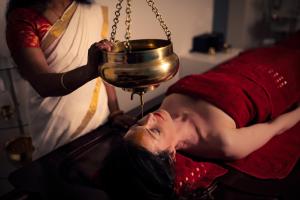 a man laying on a bed with a pot on his head at Hotel Fontana in Bad Kissingen