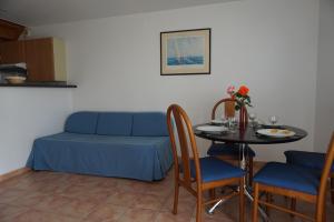 Sala de estar con cama azul y mesa en Appartement La Rochelle, en Sainte-Soulle