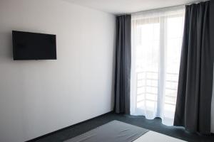 um quarto com uma grande janela e uma televisão na parede em Hotel Premium em Eforie Nord