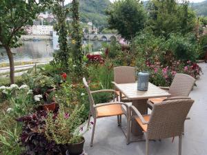 einen Tisch und Stühle im Freien mit Blumen, einem Tisch und einem Chairsktop in der Unterkunft Apartment Danijel in Višegrad