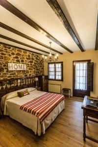 een slaapkamer met een bed en een stenen muur bij Posada Real La Montañesa in Los Corrales de Buelna