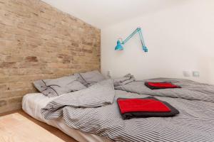a bed in a room with a brick wall at Little Whistle in the heart of Jewish district with AC in Budapest
