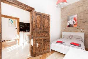 a bedroom with a bed and a wooden door at Little Whistle in the heart of Jewish district with AC in Budapest