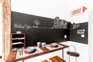 a chalkboard wall in a room with a wooden table at Little Whistle in the heart of Jewish district with AC in Budapest