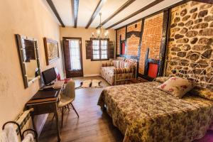 a bedroom with a bed and a desk in a room at Posada Real La Montañesa in Los Corrales de Buelna