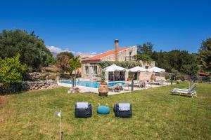 a house with a yard with a swimming pool at Boutique Villa Petra Amanda in Fílippos