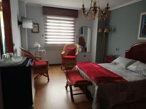 a bedroom with a bed and chairs and a mirror at O Seixo 1 in Mugardos