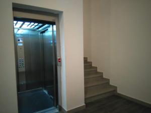 a elevator with a glass door and stairs in a building at Apartman Borislava in Trebinje