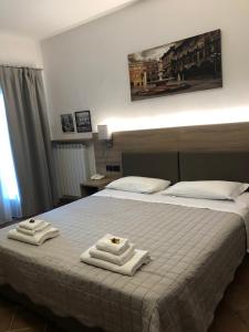 una camera d'albergo con un letto e asciugamani di Albergo Grobberio a San Martino Buon Albergo
