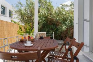 un tavolo in legno con un cesto di frutta sul balcone di Heart of Paros Apartments a Kampos Paros