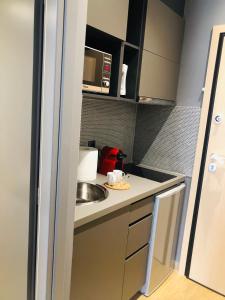 una pequeña cocina con fregadero y microondas en Metropolitan Complex Suite 2@faliro, en Pireo