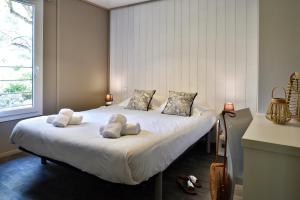 a bedroom with a large white bed with two pillows at Résidence & Hotel U Livanti ECOLABEL in Propriano