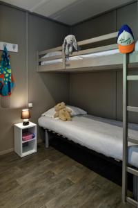 a teddy bear sitting on a bed in a bunk room at Résidence & Hotel U Livanti ECOLABEL in Propriano