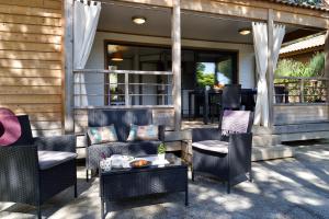 a patio with chairs and tables on a house at Résidence & Hotel U Livanti ECOLABEL in Propriano