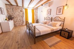 a bedroom with a bed and a stone wall at Apartment Seka Oldtown in Senj