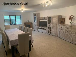 a dining room with a table and chairs and a television at Agropensiunea La Uța in Rebrişoara