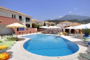 a swimming pool with chairs and umbrellas at a hotel at Georges Estates Hotel in Stoupa