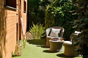 two wicker chairs and a table in a garden at Résidence & Hotel U Livanti ECOLABEL in Propriano