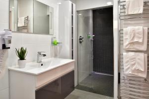 a white bathroom with a sink and a shower at Résidence & Hotel U Livanti ECOLABEL in Propriano